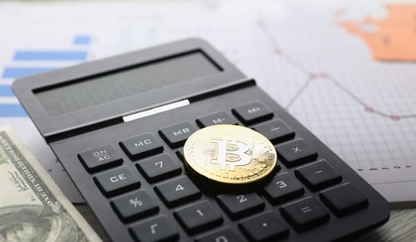 The bitcoin lies on keyboard of black calculator against background USD graph financial statistics large. Subjects growth depreciation rate rypto currency up to 10000 items of exchange transactions