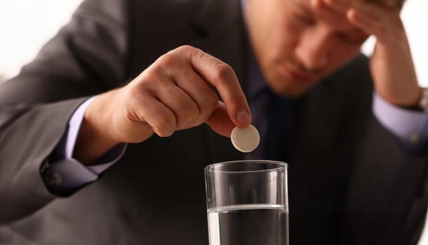 Adult male businessman hold tablet on glass water. On January 1 after celebrating the new year came to work while intoxicated closeup concept
