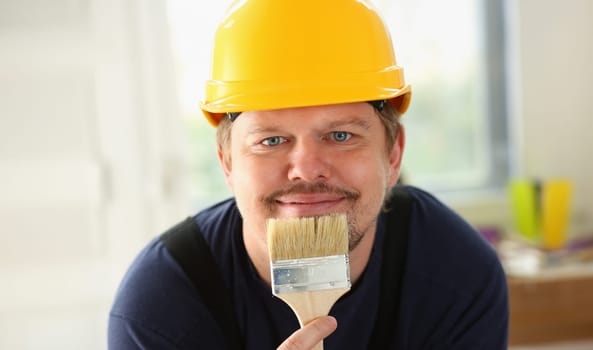 Arm of smiling worker hold brush closeup. Manual job workplace DIY inspiration improvement fix shop yellow helmet hard hat joinery startup idea industrial education profession career concept