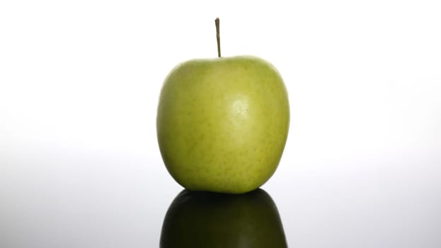 fresh green apple on a background with reflection