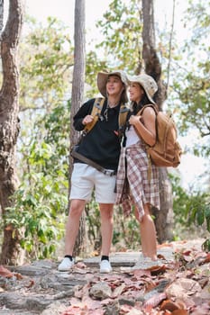 An Asian couple spends their free time on a hiking trip together..