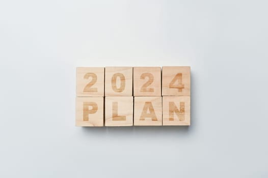 Wooden cube blocks with 2024 PLAN word on white background. Business action plan, goals and strategy concept.