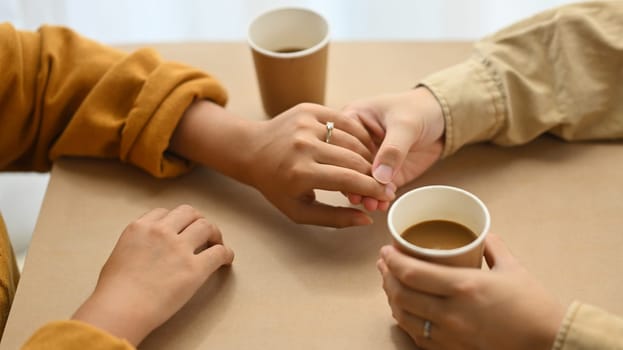 Romantic married couple holding hands on date in cafe. Love, relationship, togetherness and lifestyle concept.