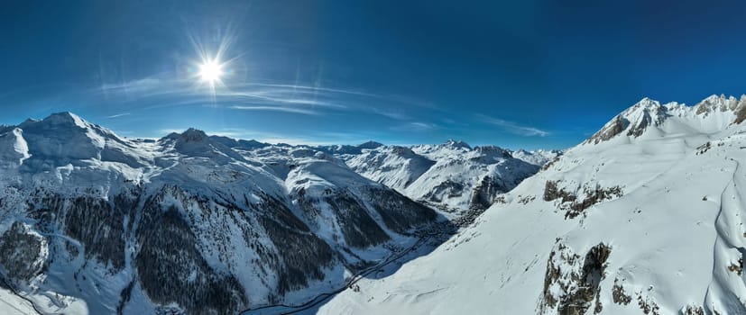 Winter drone shot of ski pistes and slopes covered with fresh powder snow in Tignes in Valdisere France. Alps aerial panoramic view on a beautiful sunny day ski lift snowboarding and skiing in resort