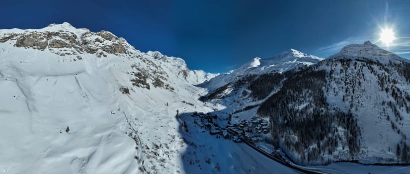 Winter drone shot of ski pistes and slopes covered with fresh powder snow in Tignes in Valdisere France. Alps aerial panoramic view on a beautiful sunny day ski lift snowboarding and skiing in resort