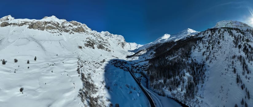 Winter drone shot of ski pistes and slopes covered with fresh powder snow in Tignes in Valdisere France. Alps aerial panoramic view on a beautiful sunny day ski lift snowboarding and skiing in resort