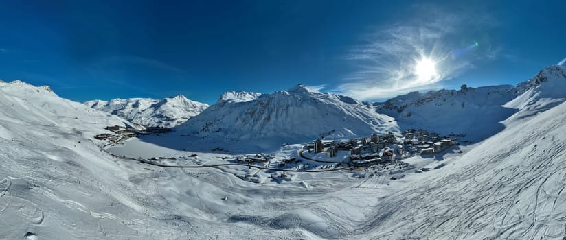 Winter drone shot of ski pistes and slopes covered with fresh powder snow in Tignes in Valdisere France. Alps aerial panoramic view on a beautiful sunny day ski lift snowboarding and skiing in resort