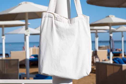 Mockup shopper handbag hanging on the beach. shopping eco reusable bag.