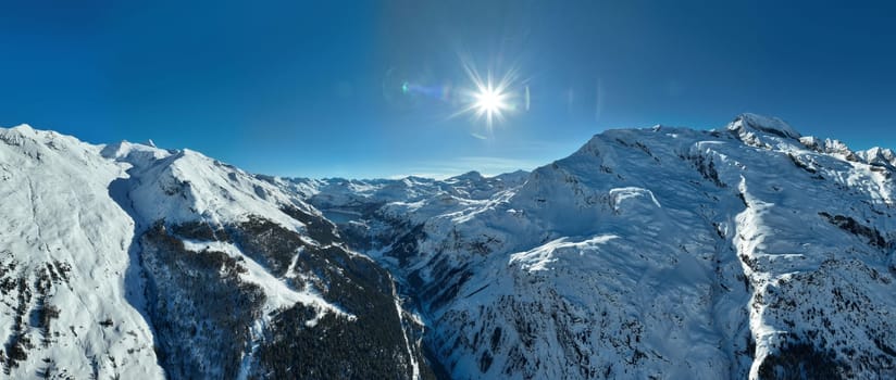 Winter drone shot of ski pistes and slopes covered with fresh powder snow in Tignes in Valdisere France. Alps aerial panoramic view on a beautiful sunny day ski lift snowboarding and skiing in resort