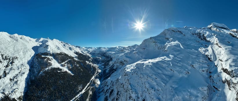 Winter drone shot of ski pistes and slopes covered with fresh powder snow in Tignes in Valdisere France. Alps aerial panoramic view on a beautiful sunny day ski lift snowboarding and skiing in resort