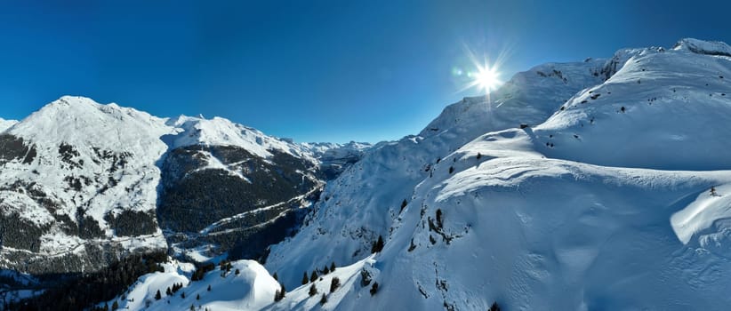 Winter drone shot of ski pistes and slopes covered with fresh powder snow in Tignes in Valdisere France. Alps aerial panoramic view on a beautiful sunny day ski lift snowboarding and skiing in resort