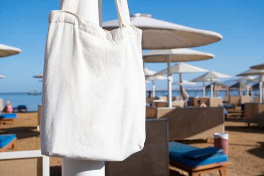 Mockup shopper handbag hanging on the beach. shopping eco reusable bag.