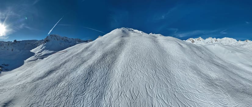 Winter drone shot of ski pistes and slopes covered with fresh powder snow in Tignes in Valdisere France. Alps aerial panoramic view on a beautiful sunny day ski lift snowboarding and skiing in resort