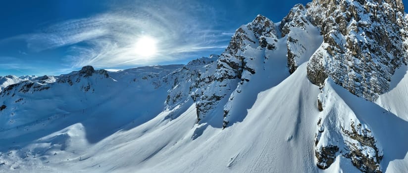 Winter drone shot of ski pistes and slopes covered with fresh powder snow in Tignes in Valdisere France. Alps aerial panoramic view on a beautiful sunny day ski lift snowboarding and skiing in resort