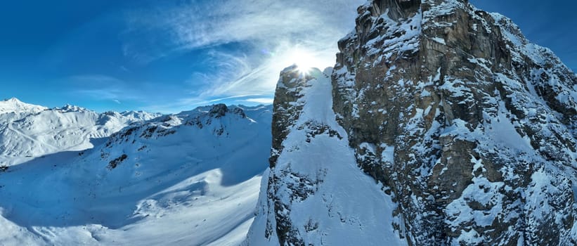 Winter drone shot of ski pistes and slopes covered with fresh powder snow in Tignes in Valdisere France. Alps aerial panoramic view on a beautiful sunny day ski lift snowboarding and skiing in resort