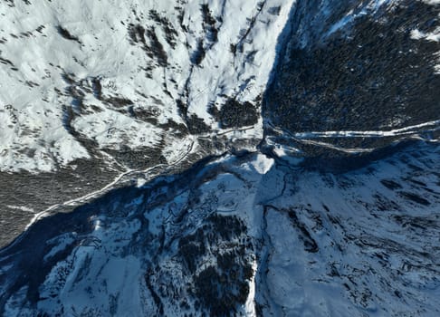 Winter drone shot of ski pistes and slopes covered with fresh powder snow in Tignes in Valdisere France. Alps aerial panoramic view on a beautiful sunny day ski lift snowboarding and skiing in resort