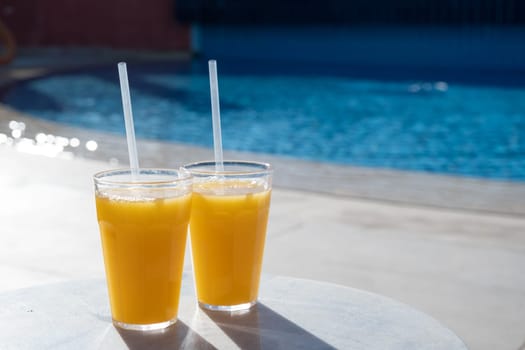 Refreshing cocktails near swimming pool, close up, copy space
