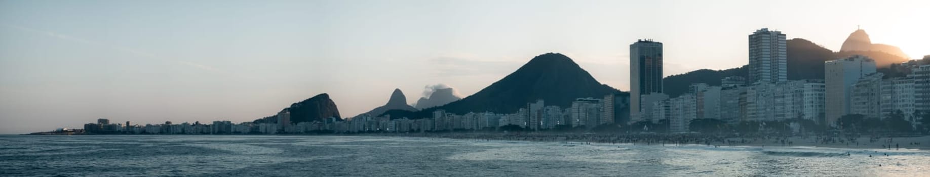 Tranquil view of Rio de Janeiro's skyline featuring Sugarloaf Mountain at sunset.