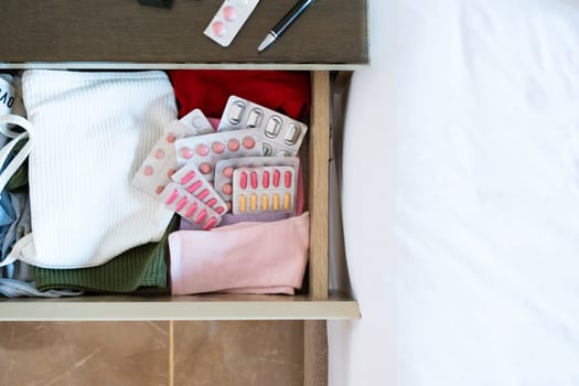 Travel concept. opened beside table on bed in hotel room, pills and medicine