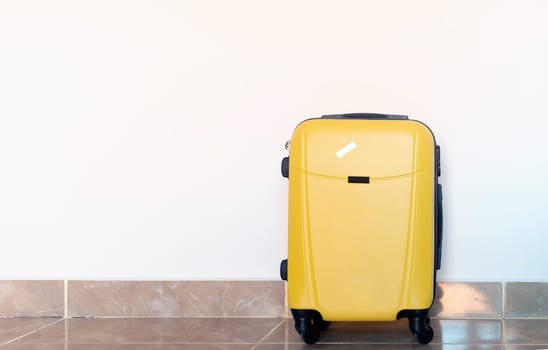 yellow suitcases on white wall background in hotel room