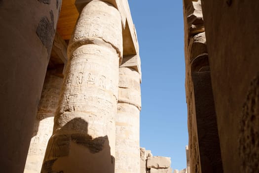 the ruins of the ancient Karnak temple in the city of Luxor in Egypt. Great row of columns with carved hieroglyph