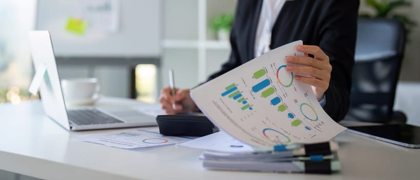 Business accounting woman counting on calculator working on financial document in hands closeup. Bookkeeping concept.