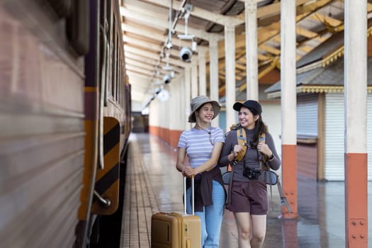 two young beautiful female women at station to catch train for their vacation together.