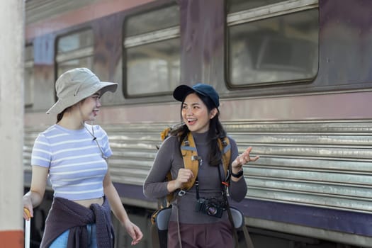 two young beautiful female women at station to catch train for their vacation together.