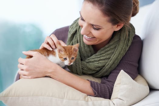 Happy, sofa and woman with kitten in home for bonding, friendship and relax together in house. Animal care, pets and person with adorable, cute and young cat on couch for playing, affection and love.