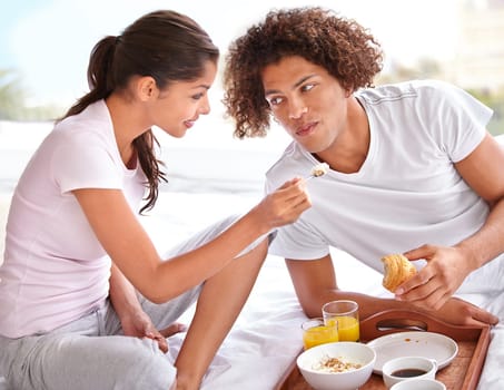 Couple, feeding and breakfast in bed for bonding, healthy meal and celebrating anniversary at home. People, marriage milestone and love or loyalty in relationship, romance and food for nutrition.