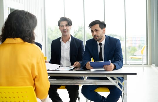 Job interview concept. Diverse hr team doing job interview with a man in business office. Human resources team interviewing a potential job candidate. Hiring, employment, and recruitment concept.