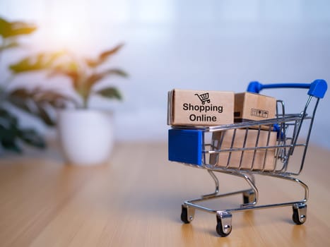 Online shopping, Product package boxes in cart with shopping bag  delivery concept, Shopping service on The online web and offers home delivery, online shopping and delivery concept.