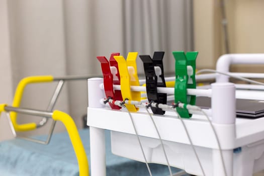 Close up of Multi-colored clips for electrodiagnosis, on a medical trolley, against the background of a hospital adjustable bed