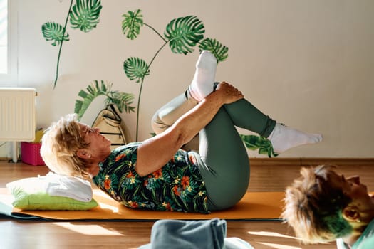 In a sunlit space, a senior woman gracefully practices rejuvenating yoga, focusing on neck, back, and leg stretches, embodying serenity and well-being.