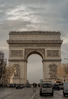 France, Paris - Jan 03, 2024 - Famous Arc de Triomphe (Triumphal Arch) at the city center of Paris and traffic trails in Chaps Elysees. Symbol of the glory and historical heritage, Iconic touristic architectural landmark, Tourism and travel concept, Space for text, Selective focus.