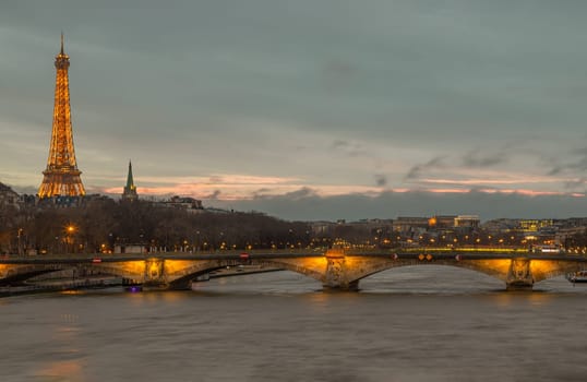 France, Paris - Jan 4, 2024 - Nice scenery of Eiffel Tower and Seine River in Paris. View from Pont Alexandre III Bridge at sunset. Destinations in Europe. Space for text, Selective focus.