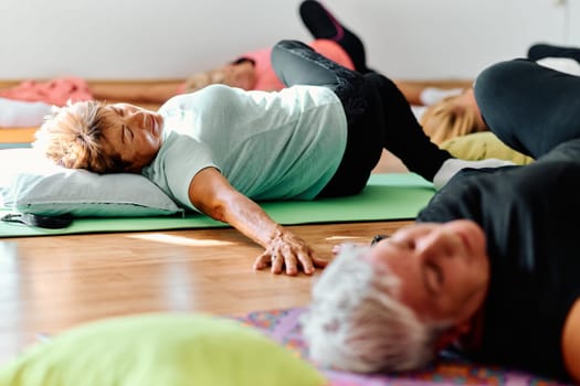 A group of senior women engage in various yoga exercises, including neck, back, and leg stretches, under the guidance of a trainer in a sunlit space, promoting well-being and harmony.