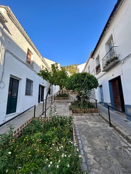 A narrow alley way with white buildings in the background. High quality photo