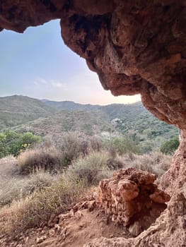 A view from inside of a cave in the mountains. High quality photo
