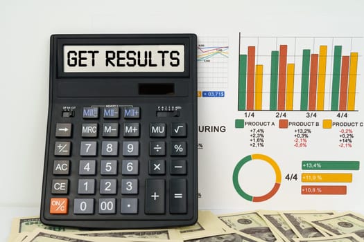 Business concept. On the table are financial reports, dollars and a calculator with the inscription - get results