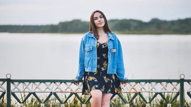 Portrait of a lonely girl by a lake