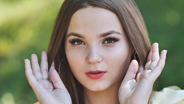 Portrait of a young girl in a park. Close-up of her face