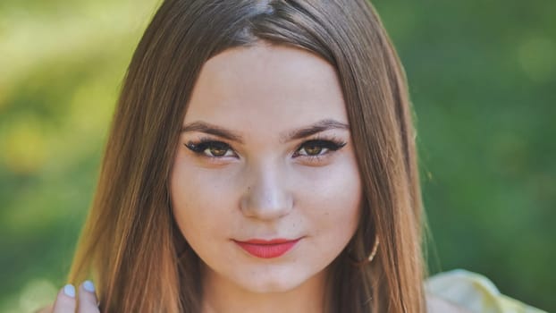 Portrait of a young girl in a park. Close-up of her face