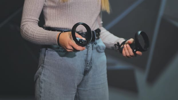 The girl plays virtual reality games in the club. Close-up controllers