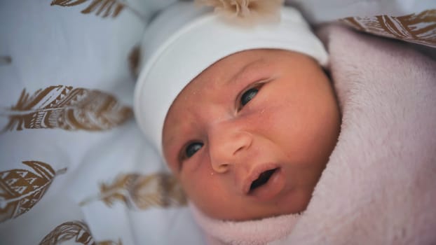 A newborn baby wrapped up in a maternity hospital and looking forward to a trip home