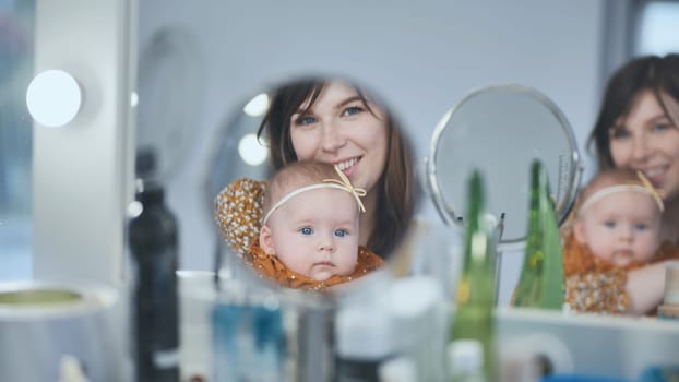 A loving mother and her child at the makeup mirror