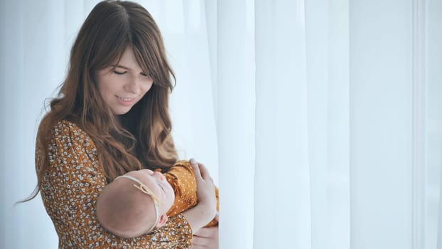 A loving mother and child at the window with curtains