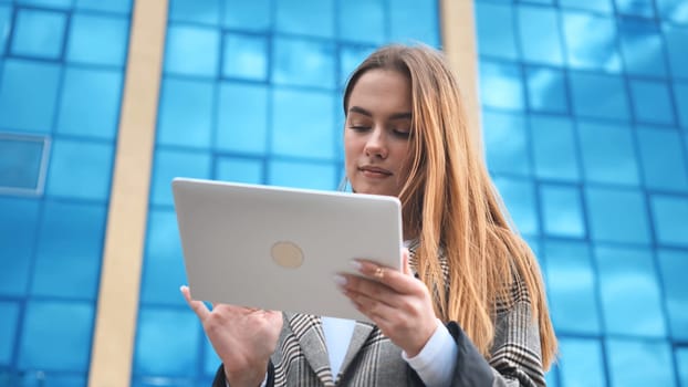 A young girl student works with a white tablet in the city