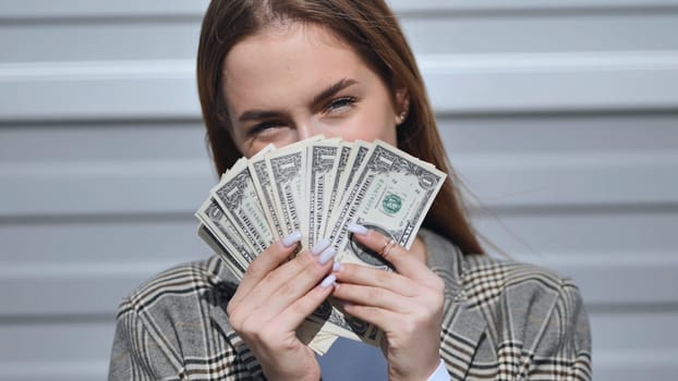 Young girl showing dollars in the street