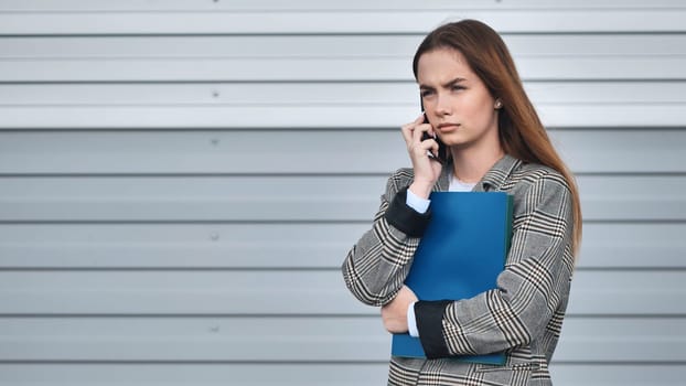 A student girl in a blazer talking on the phone